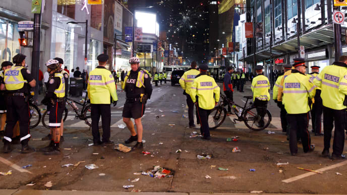 TORONTO, ON - JUNE 14: Fireworks are seen beyond a line of Toronto Police officers amidst celebrations on Yonge St. after the Toronto Raptors beat the Golden State Warriors in Game Six of the NBA Finals, on June 14, 2019 in Toronto, Canada. (Photo by Cole Burston/Getty Images) TORONTO, ON - JUNE 14: Fireworks are seen beyond a line of Toronto Police officers amidst celebrations on Yonge St. after the Toronto Raptors beat the Golden State Warriors in Game Six of the NBA Finals, on June 14, 2019 in Toronto, Canada. (Photo by Cole Burston/Getty Images)