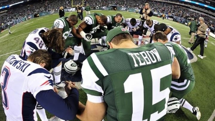 Nov 22, 2012; East Rutherford, NJ, USA; New York Jets quarterback Tim Tebow (15) leads his teammates and New England Patriots players in prayer after the game on Thanksgiving at Metlife Stadium. The Patriots won the game 49-19. Mandatory Credit: Joe Camporeale-USA TODAY Sports