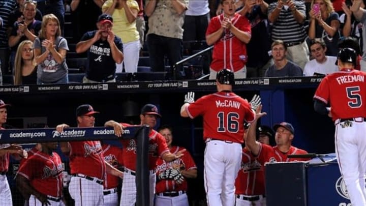 Sep 13, 2013; Atlanta, GA, USA; Atlanta Braves catcher Brian McCann (16) high fives manager Fredi Gonzalez (right) after hitting a home run against the San Diego Padres during the fourth inning at Turner Field. Mandatory Credit: Dale Zanine-USA TODAY Sports