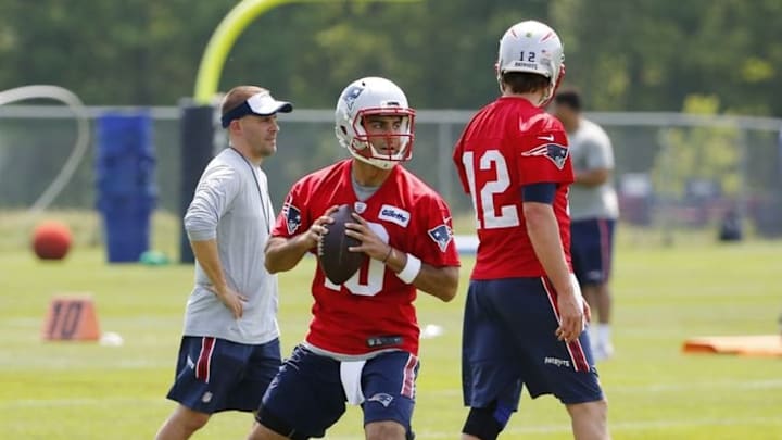 May 26, 2016; Foxborough, MA, USA; New England Patriots quarterback Tom Brady (12) and offensive coordinator Josh McDaniels walk past quarterback Jimmy Garoppolo (10) as he drops back to pass during OTA