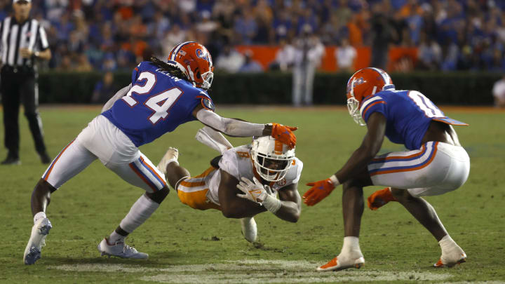 Sep 25, 2021; Gainesville, Florida, USA;Tennessee Volunteers running back Tiyon Evans (8) runs with the ball as Florida Gators cornerback Avery Helm (24) and safety Trey Dean III (0) defends during the third quarter at Ben Hill Griffin Stadium. Mandatory Credit: Kim Klement-USA TODAY Sports
