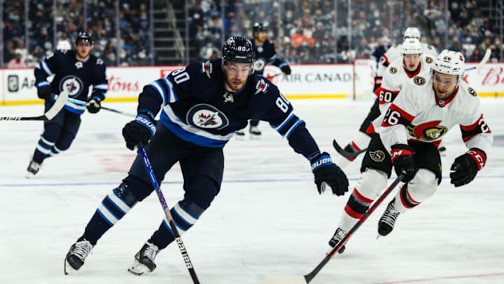 Sep 26, 2021; Winnipeg, Manitoba, CAN; Winnipeg Jets forward Pierre-Luv Dubois(80) skates around Ottawa Senators defenseman Erik Brannstrom (26) during the first period at Canada Life Centre. Mandatory Credit: Terrence Lee-USA TODAY Sports