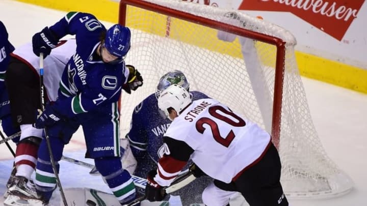Oct 3, 2016; Vancouver, British Columbia, CAN; Arizona Coyotes forward Dylan Strome (20) shoots the puck against Vancouver Canucks goaltender Jacob Markstrom (25) and defenseman Ben Hutton (27) during the third period during a preseason hockey game at Rogers Arena. The Arizona Coyotes won 4-2. Mandatory Credit: Anne-Marie Sorvin-USA TODAY Sports
