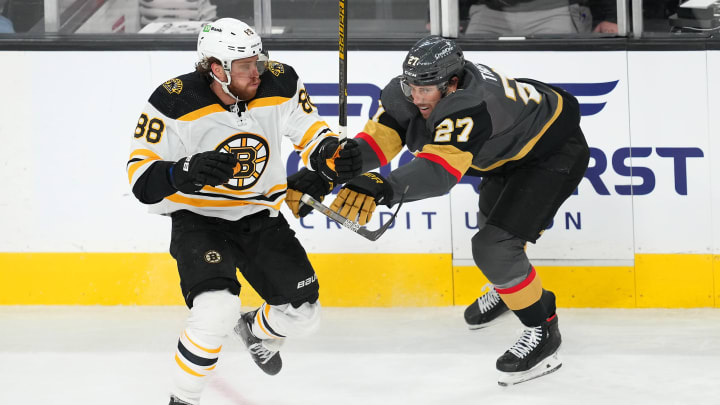 Mar. 3, 2022; Las Vegas, Nevada, USA; Boston Bruins right wing David Pastrnak (88) skates around the checking attempt of Vegas Golden Knights defenseman Shea Theodore (27) during the second period at T-Mobile Arena. Mandatory Credit: Stephen R. Sylvanie-USA TODAY Sports