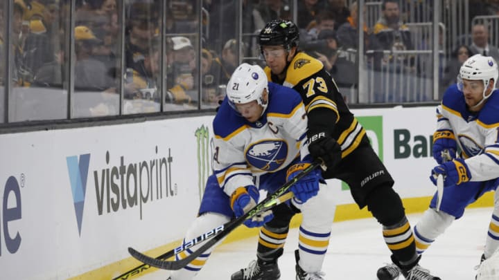 Mar 2, 2023; Boston, Massachusetts, USA; Boston Bruins defenseman Charlie McAvoy (73) battles Buffalo Sabres right wing Kyle Okposo (21) for the puck during the second period at TD Garden. Mandatory Credit: Winslow Townson-USA TODAY Sports