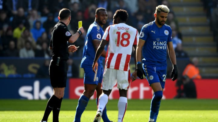 LEICESTER, ENGLAND - FEBRUARY 24: Referee Michael Oliver books Mame Biram Diouf of Stoke City during the Premier League match between Leicester City and Stoke City at The King Power Stadium on February 24, 2018 in Leicester, England. (Photo by Ross Kinnaird/Getty Images)