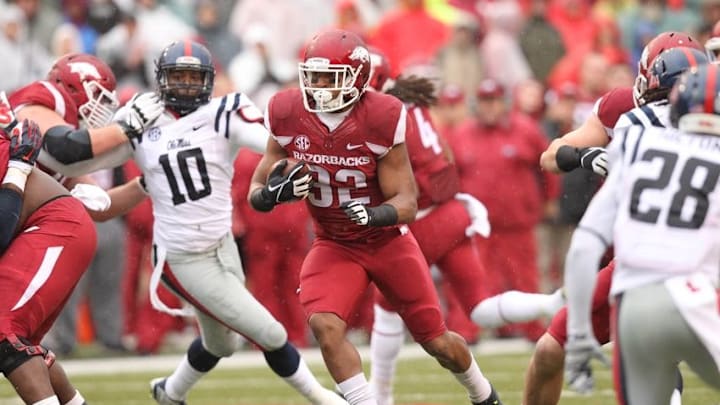 Nov 22, 2014; Fayetteville, AR, USA; Arkansas Razorbacks running back Jonathan Williams (32) rushes during the first quarter as Ole Miss Rebels defensive end C.J. Johnson (10) looks on at Donald W. Reynolds Razorback Stadium. Mandatory Credit: Nelson Chenault-USA TODAY Sports