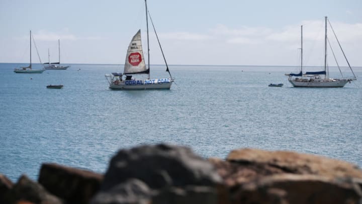 AIRLIE BEACH, AUSTRALIA - APRIL 26: A boat launches a sail in protest to the Adani Carmichael Coal Mine proposal on April 26, 2019 in Airlie Beach, Australia. Former Greens leader and conservationist, Bob Brown, has been leading a convoy of environmental activists through the Southern States towards Central Queensland as part of the #StopAdani movement. With primary concerns for increased coal ship travel through the Great Barrier Reef World Heritage Area, unlocking of the Galilee Basin and increase in carbon pollution. The proposed Adani Carmichael Mine, if approved will be constructed in the North Galilee Basin, 160kms north-west of regional town Clermont, its first stage is estimated to produce 27.5 million tonnes of coal per annum and will be transported via rail to Abbot Point which is situated 25km north of Bowen. (Photo by Lisa Maree Williams/Getty Images)