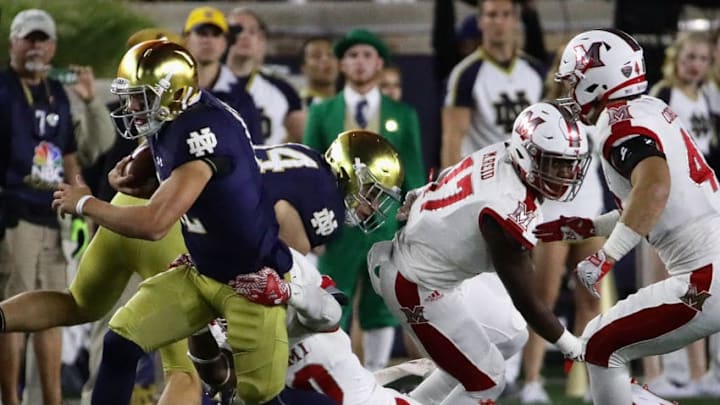 SOUTH BEND, IN - SEPTEMBER 30: Ian Book #12 of the Notre Dame Fighting Irish is tackled by Josh Maize #30 of the Miami (Oh) Redhawks at Notre Dame Stadium on Seotember 30, 2017 in South Bend, Indiana. (Photo by Jonathan Daniel/Getty Images)