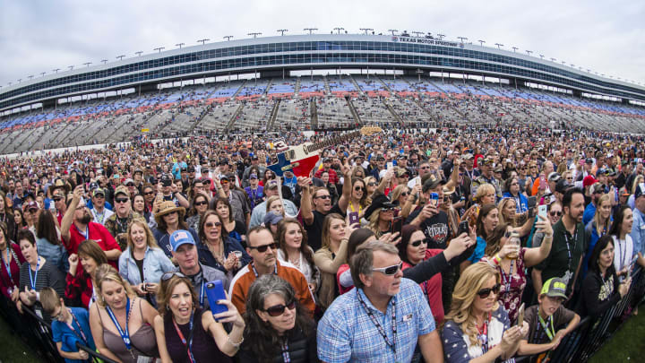 Nov 6, 2016; Fort Worth, TX, USA; A fan holds up a Texas shaped guitar as the fans of country musician Jake Owen (not pictured) watches his concert before the AAA Texas 500 at Texas Motor Speedway. Mandatory Credit: Jerome Miron-USA TODAY Sports