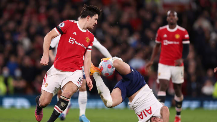 MANCHESTER, ENGLAND - MARCH 12: Harry Kane of Tottenham Hotspur controls the ball as Harry Maguire of Manchester United looks on during the Premier League match between Manchester United and Tottenham Hotspur at Old Trafford on March 12, 2022 in Manchester, United Kingdom. (Photo by Matthew Ashton - AMA/Getty Images)