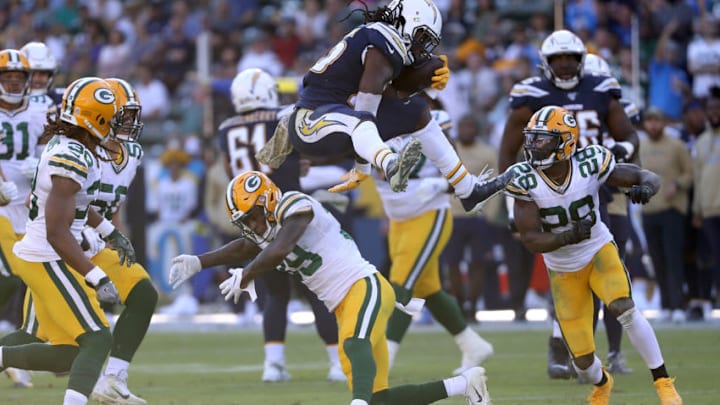 CARSON, CALIFORNIA - NOVEMBER 03: Melvin Gordon #25 of the Los Angeles Chargers leaps over Chandon Sullivan #39 of the Green Bay Packers as Tony Brown #28 of the Green Bay Packers defends during the second half of a game at Dignity Health Sports Park on November 03, 2019 in Carson, California. (Photo by Sean M. Haffey/Getty Images)