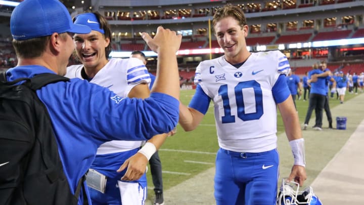 Sep 16, 2023; Fayetteville, Arkansas, USA; BYU Cougars quarterback Kedon Slovis (10) celebrates with a teammate and team personnel after the game against the Arkansas Razorbacks at Donald W. Reynolds Razorback Stadium. BYU won 38-31. Mandatory Credit: Nelson Chenault-USA TODAY Sports