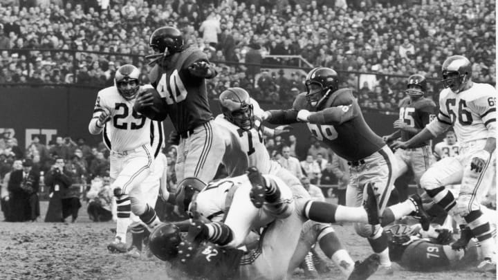American professional football player Joe Morrison #40 (1937 – 1989), of the New York Giants, rushes through the Philadelphia Eagles as teammates Jack Stroud #66, Phil King #24, and Roosevelt Brown #79 (1932 – 2004), block from both uproght and prone positions, Philadelphia, late 1950s or early 1960s. (Photo by Robert Riger/Getty Images)