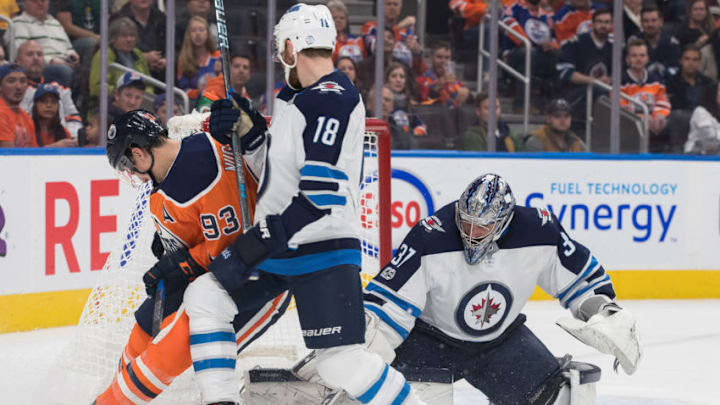 EDMONTON, AB - OCTOBER 09: Winnipeg Jets Goalie Connor Hellebuyck (37) makes a save on Edmonton Oilers Center Ryan Nugent-Hopkins (93) while Winnipeg Jets Center Bryan Little (18) ties him up during the Edmonton Oilers game versus the Winnipeg Jets at Rogers Place in Edmonton, AB (Photo by Curtis Comeau/Icon Sportswire via Getty Images)