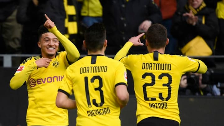 Dortmund's English midfielder Jadon Sancho (L), Dortmund's Portuguese defender Raphael Guerreiro and Dortmund's Belgian forward Thorgan Hazard (R) celebrate a goal during the German first division Bundesliga football match Borussia Dortmund v SC Freiburg on February 29, 2020 in Dortmund. (Photo by Ina FASSBENDER / AFP) / DFL REGULATIONS PROHIBIT ANY USE OF PHOTOGRAPHS AS IMAGE SEQUENCES AND/OR QUASI-VIDEO (Photo by INA FASSBENDER/AFP via Getty Images)