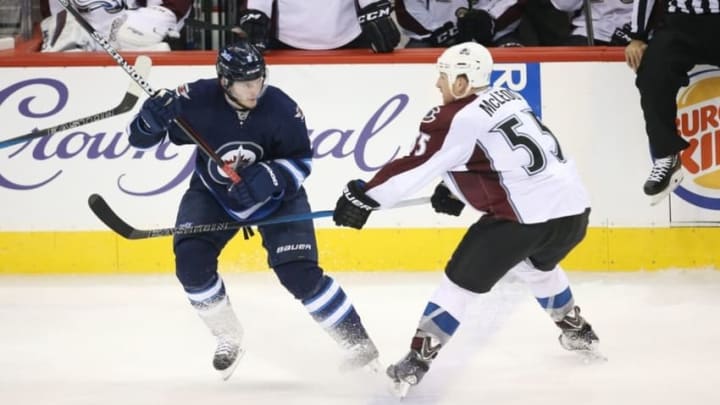 Nov 23, 2015; Winnipeg, Manitoba, CAN; Winnipeg Jets defenseman Jacob Trouba (8) braces for a hit by Colorado Avalanche left wing Cody McLeod (55) during the second period at MTS Centre. Mandatory Credit: Bruce Fedyck-USA TODAY Sports