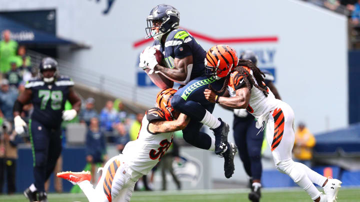 SEATTLE, WASHINGTON – SEPTEMBER 08: D.K. Metcalf #14 of the Seattle Seahawks completes a pass against Jessie Bates #30 (L) and B.W. Webb #23 of the Cincinnati Bengals in the third quarter during their game at CenturyLink Field on September 08, 2019 in Seattle, Washington. (Photo by Abbie Parr/Getty Images)