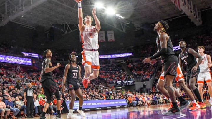 Jan 11, 2023; Clemson, South Carolina, USA; Clemson Tigers forward Hunter Tyson (5) scores near Louisville Cardinals forward Kamari Lands (22) during the second half at Littlejohn Coliseum. Mandatory Credit: Ken Ruinard-USA TODAY Sports