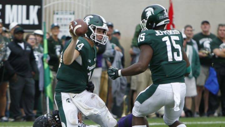 EAST LANSING, MI - OCTOBER 6: Quarterback Brian Lewerke #14 of the Michigan State Spartans gets a pass off as he is tackled by safety Jared McGee #41 of the Northwestern Wildcats as running back La'Darius Jefferson #15 of the Michigan State Spartans looks on during the second half at Spartan Stadium on October 6, 2018 in East Lansing, Michigan. Northwestern defeated Michigan State 29-19. (Photo by Duane Burleson/Getty Images)