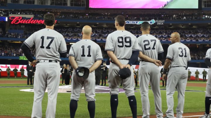 TORONTO, ON - MARCH 29: Manager Aaron Boone #17 of the New York Yankees and Brett Gardner #11 and Aaron Judge #99 and Giancarlo Stanton #27 and Aaron Hicks #31 line up on the first base line during the playing of the national anthems on Opening Day before the start of MLB game action against the Toronto Blue Jays at Rogers Centre on March 29, 2018 in Toronto, Canada. (Photo by Tom Szczerbowski/Getty Images) *** Local Caption *** Aaron Boone;Brett Gardner;Aaron Judge;Giancarlo Stanton;Aaron Hicks