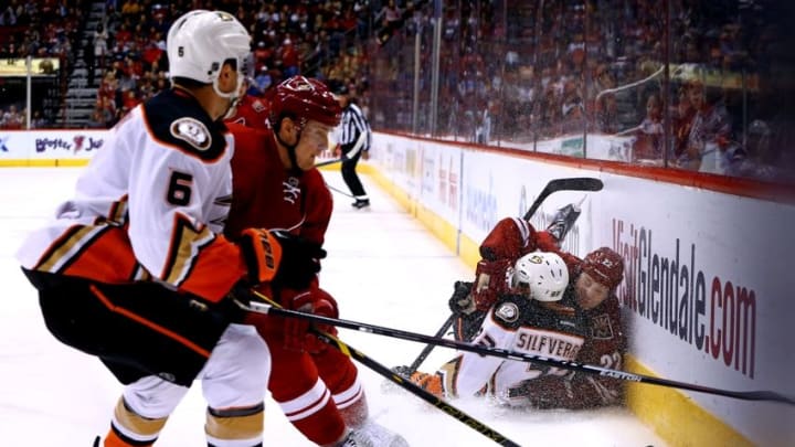 Dec 27, 2014; Glendale, AZ, USA; Arizona Coyotes left wing Brandon McMillan (22) and Anaheim Ducks right wing Jakob Silfverberg (33) fall to the ice after colliding in the first period at Gila River Arena. The Coyotes defeated the Ducks 2-1 in an overtime shootout. Mandatory Credit: Mark J. Rebilas-USA TODAY Sports