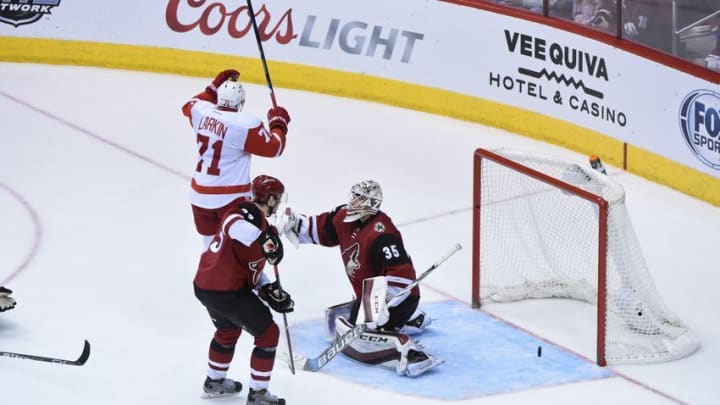 Jan 14, 2016; Glendale, AZ, USA; Detroit Red Wings center Dylan Larkin (71) celebrates an overtime goal by defenseman Danny DeKeyser (65) to win the game 3-2 as Arizona Coyotes goalie Louis Domingue (35) and defenseman Oliver Ekman-Larsson (23) react at Gila River Arena. Mandatory Credit: Matt Kartozian-USA TODAY Sports