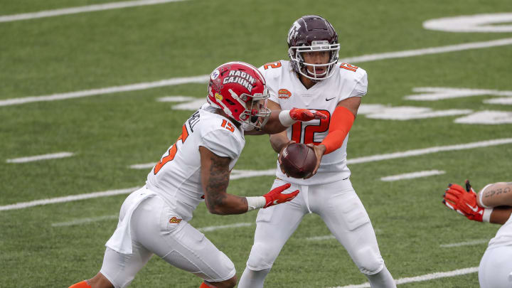 MOBILE, AL – JANUARY 30: Runningback Elijah Mitchell #15 from Louisiana takes an hand off from Quarterback Kellen Mond #12 from Texas A&M of the American Team during the 2021 Resse’s Senior Bowl at Hancock Whitney Stadium on the campus of the University of South Alabama on January 30, 2021 in Mobile, Alabama. The National Team defeated the American Team 27-24. (Photo by Don Juan Moore/Getty Images)