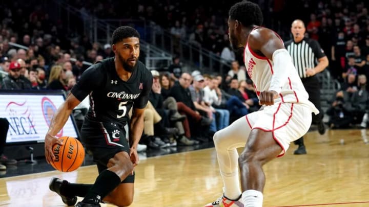 Cincinnati Bearcats guard David DeJulius crosses over as Houston Cougars guard Jamal Shead at Fifth Third Arena. The Enquirer.