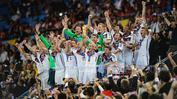 RIO DE JANEIRO, BRAZIL – JULY 13: Philipp Lahm of Germany lifts the World Cup trophy with teammates after defeating Argentina 1-0 in extra time during the 2014 FIFA World Cup Brazil Final match between Germany and Argentina at Maracana on July 13, 2014 in Rio de Janeiro, Brazil. (Photo by Matthias Hangst/Getty Images)