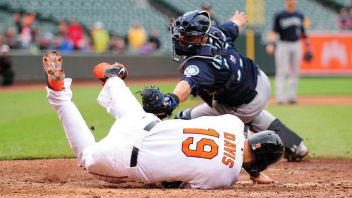 May 21, 2015; Baltimore, MD, USA; Baltimore Orioles first baseman Chris Davis (19) avoids the tag of Seattle Mariners catcher Wellington Castillo (35), to score the go ahead run in the eighth inning at Oriole Park at Camden Yards. Mandatory Credit: Evan Habeeb-USA TODAY Sports