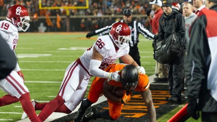 Nov 28, 2015; Stillwater, OK, USA; Oklahoma State Cowboys running back Chris Carson (32) is pushed out of bounds by Oklahoma Sooners linebacker Jordan Evans (26) during the second half at Boone Pickens Stadium. Oklahoma won 58-23. Mandatory Credit: Rob Ferguson-USA TODAY Sports