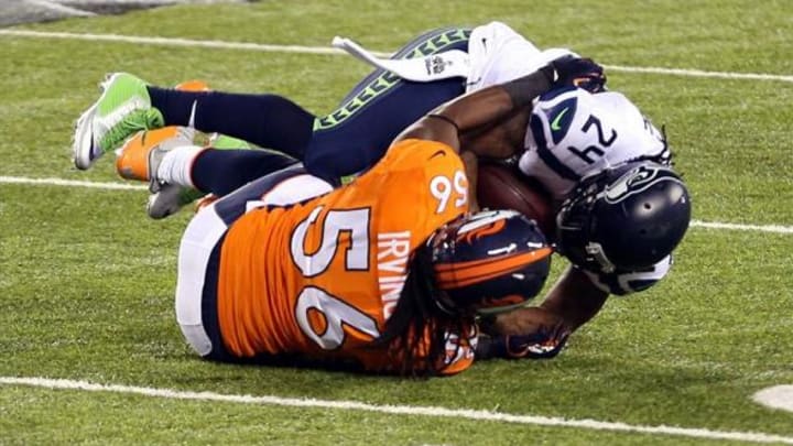 Feb 2, 2014; East Rutherford, NJ, USA; Seattle Seahawks running back Marshawn Lynch (24) is tackled by Denver Broncos outside linebacker Nate Irving (56) in the first quarter in Super Bowl XLVIII at MetLife Stadium. Mandatory Credit: Joe Camporeale-USA TODAY Sports