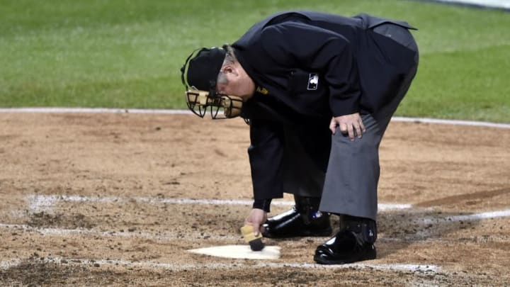 Nov 1, 2016; Cleveland, OH, USA; Home plate umpire Joe West (22) cleans the plate in game six of the 2016 World Series between the Chicago Cubs and the Cleveland Indians at Progressive Field. Mandatory Credit: David Richard-USA TODAY Sports
