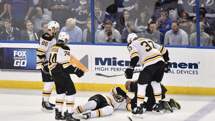 TAMPA, FL - MAY 06: Teammates and trainer take care of an injured Boston Bruins right wing David Backes (42) during the second period of an NHL Stanley Cup Eastern Conference Playoffs game between the Boston Bruins and the Tampa Bay Lightning on May 06, 2018, at Amalie Arena in Tampa, FL. (Photo by Roy K. Miller/Icon Sportswire via Getty Images)