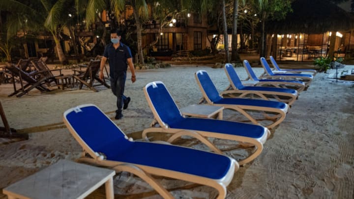 Boracay Island, PHILIPPINES - SEPTEMBER 30: A worker walks past chairs at a resort on September 30, 2020 in Boracay Island, Philippines. The Philippines is reopening Boracay Island, a popular tourist destination known for its resorts and beaches, to more visitors starting October 1 in a bid to revive its pandemic-hit tourism sector. Tourism accounted for almost 13% of the Philippines economic output last year, according to the Department of Tourism. The reopening of Boracay comes as the nation tries to stimulate the economy even as coronavirus cases continue to rise. The country surpassed 312,000 cases of COVID-19, with at least 5,504 deaths. (Photo by Ezra Acayan/Getty Images)