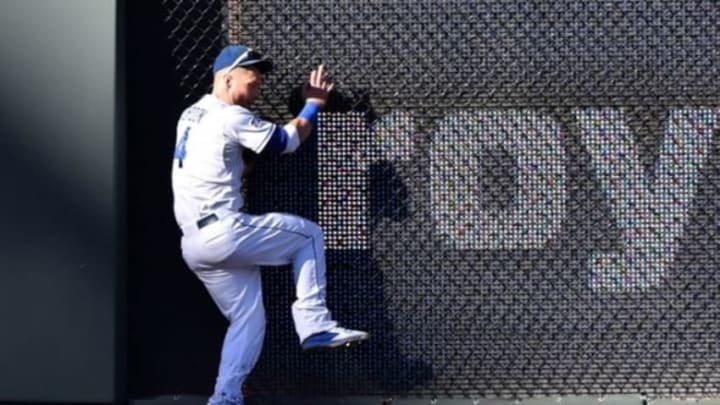 Oct 15, 2014; Kansas City, MO, USA; Kansas City Royals left fielder Alex Gordon crashes into the wall after catching a fly ball hit by Baltimore Orioles shortstop J.J. Hardy (not pictured) during the fifth inning in game four of the 2014 ALCS playoff baseball game at Kauffman Stadium. Mandatory Credit: Peter G. Aiken-USA TODAY Sports