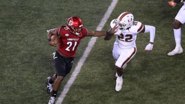 LOUISVILLE, KENTUCKY - SEPTEMBER 19: Aidan Robbins #21 of the Louisville Cardinals runs with the ball while defended by Cameron Williams #22 of the Miami Hurricanes at Cardinal Stadium on September 19, 2020 in Louisville, Kentucky. (Photo by Andy Lyons/Getty Images)