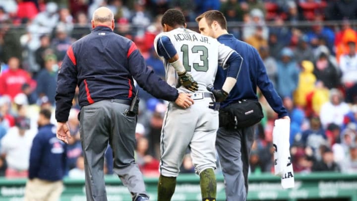 BOSTON, MA - MAY 27: Ronald Acuna Jr. #13 of the Atlanta Braves is helped off the field after an injury at first base in the seventh inning of a game against the Atlanta Braves at Fenway Park on May 27, 2018 in Boston, Massachusetts. (Photo by Adam Glanzman/Getty Images)