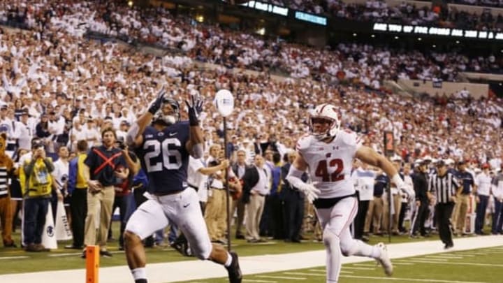 Dec 3, 2016; Indianapolis, IN, USA; Penn State Nittany Lions running back Saquon Barkley (26) catches a touchdown pass against Wisconsin Badgers linebacker T.J. Watt (42) in the second half during the Big Ten Championship college football game at Lucas Oil Stadium. Mandatory Credit: Brian Spurlock-USA TODAY Sports