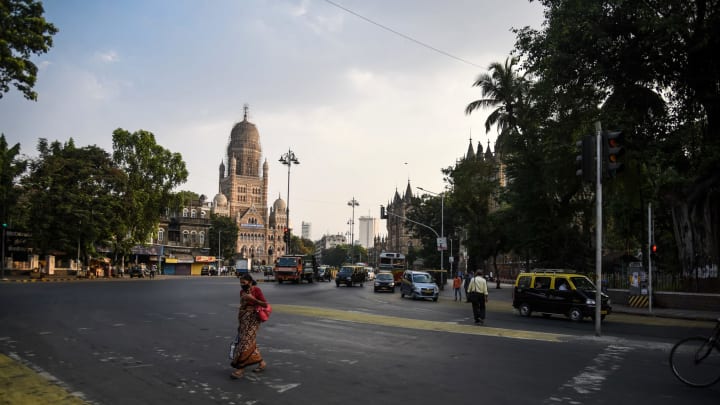 MUMBAI, INDIA – APRIL 29: A pedestrian walks along a near-deserted street during a lockdown imposed to try and contain the spread of Covid-19 on April 29, 2021 in Mumbai, India. With recorded cases crossing 380,000 a day and 3000 deaths in the last 24 hours, India has more than 2 million active cases of Covid-19, the second-highest number in the world after the U.S. A new wave of the pandemic has totally overwhelmed the country’s healthcare services and has caused crematoriums to operate day and night as the number of victims continues to spiral out of control. (Photo by Fariha Farooqui/Getty Images)