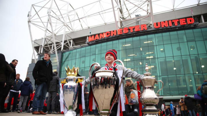 MANCHESTER, ENGLAND - JANUARY 05: A young Manchester United fan pose for a photo with replicas of the Premier League Trophy, The UEFA Champions League Trophy and the FA Cup Trophy outside the stadium prior to the FA Cup Third Round match between Manchester United and Reading at Old Trafford on January 5, 2019 in Manchester, United Kingdom. (Photo by Clive Brunskill/Getty Images)