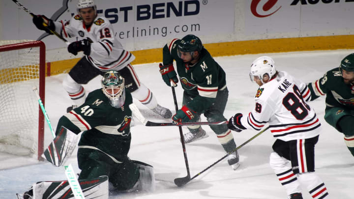 ST. PAUL, MN - OCTOBER 11: Devan Dubnyk #40 of the Minnesota Wild makes a save on Patrick Kane #88 of the Chicago Blackhawks as Zach Parise #11 of the Minnesota Wild defends and Alex DeBrincat #12 of the Chicago Blackhawks looks on during a game between the Minnesota Wild and Chicago Black Hawks at Xcel Energy Center on October 11, 2018 in St. Paul, Minnesota. The Wild defeated the Black Hawks 4-3 in overtime.(Photo by Bruce Kluckhohn/NHLI via Getty Images)