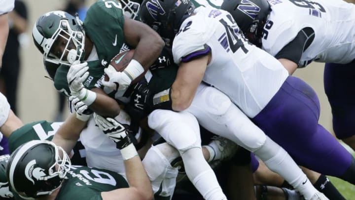 EAST LANSING, MI - OCTOBER 6: Running back Weston Bridges #27 of the Michigan State Spartans is tackled by linebacker Paddy Fisher #42 of the Northwestern Wildcats during the first half at Spartan Stadium on October 6, 2018 in East Lansing, Michigan. (Photo by Duane Burleson/Getty Images)