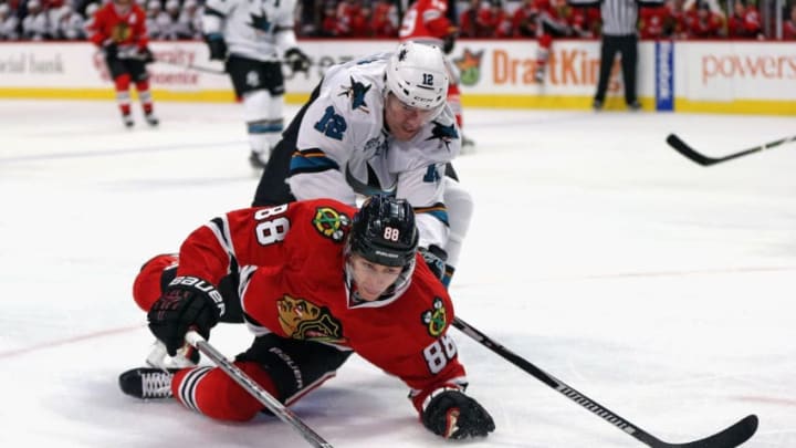 CHICAGO, IL - DECEMBER 20: Patrick Kane #88 of the Chicago Blackhawks is knocked to the ice by Patrick Marleau #12 of the San Jose Sharks at the United Center on December 20, 2015 in Chicago, Illinois. (Photo by Jonathan Daniel/Getty Images)