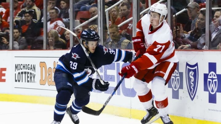 Mar 10, 2016; Detroit, MI, USA; Detroit Red Wings center Dylan Larkin (71) makes a pass defended by Winnipeg Jets defenseman Toby Enstrom (39) in the third period at Joe Louis Arena. Detroit won 3-2. Mandatory Credit: Rick Osentoski-USA TODAY Sports