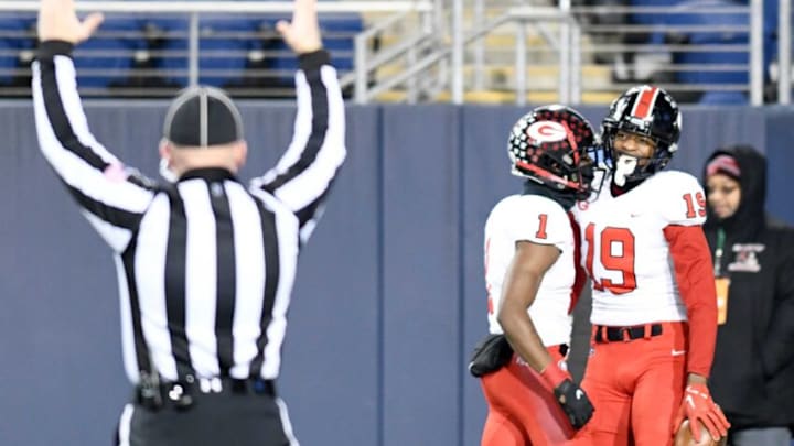 Glenville's Demarion Witten (19) celebrates his first-quarter TD catch with teammate Jermaine Foster vs. Wyoming in the OHSAA Division IV state final at Tom Benson Hall of Fame Stadium. Saturday, Dec. 3, 2022.Gallery D4 State Fb 06
