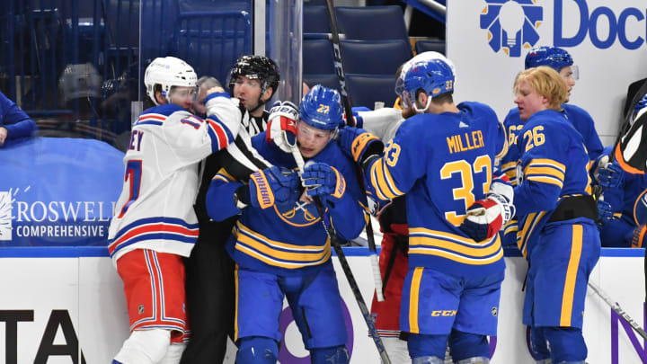 New York Rangers center Kevin Rooney (17) tries to get to Buffalo Sabres defenseman Rasmus Dahlin (26) for a hard hit on the boards. Credit: Mark Konezny-USA TODAY Sports