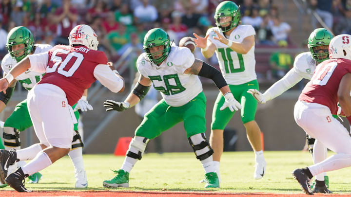 PALO ALTO, CA – SEPTEMBER 21: Shane Lemieux #68 of the Oregon Ducks blocks during an NCAA Pac-12 college football game against the Stanford Cardinal on September 21, 2019 at Stanford Stadium in Palo Alto, California. Oregon quarterback Justin Herbert is visible behind, Dalyn Wade-Perry #50 of Stanford at left. (Photo by David Madison/Getty Images)