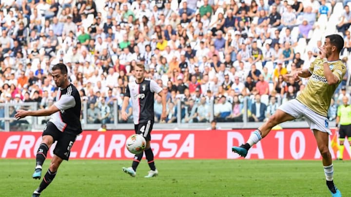 Juventus' Bosnian midfielder Miralem Pjanic (L) shoots to open the scoring despite Spal's Italian midfielder Mirko Valdifiori (R) during the Italian Serie A football match Juventus vs Spal on September 28, 2019 at the Juventus stadium in Turin. (Photo by Andreas SOLARO / AFP) (Photo credit should read ANDREAS SOLARO/AFP/Getty Images)